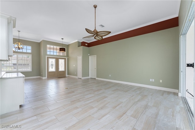 unfurnished living room featuring ornamental molding and ceiling fan with notable chandelier