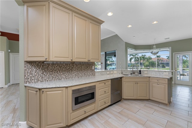 kitchen featuring ornamental molding, light stone countertops, light wood-type flooring, and sink