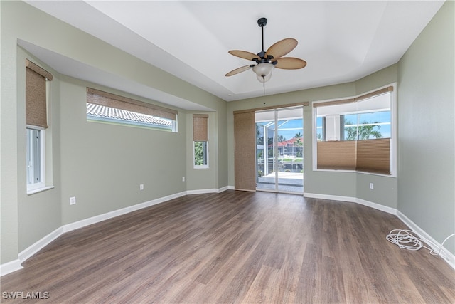 empty room with ceiling fan and dark hardwood / wood-style flooring