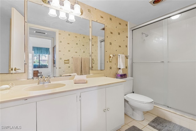 bathroom with vanity, toilet, walk in shower, and tile patterned flooring