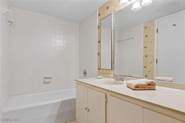 bathroom featuring tiled shower / bath combo and vanity