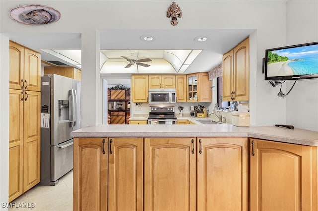 kitchen featuring stainless steel appliances, sink, kitchen peninsula, light tile patterned flooring, and ceiling fan