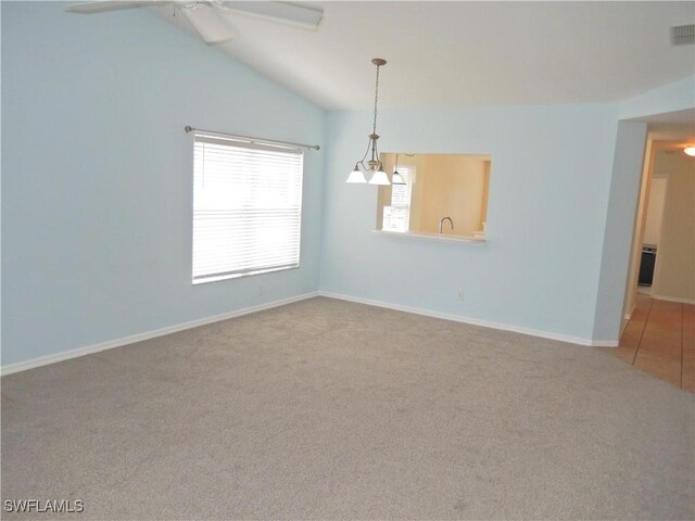 carpeted empty room featuring ceiling fan and vaulted ceiling