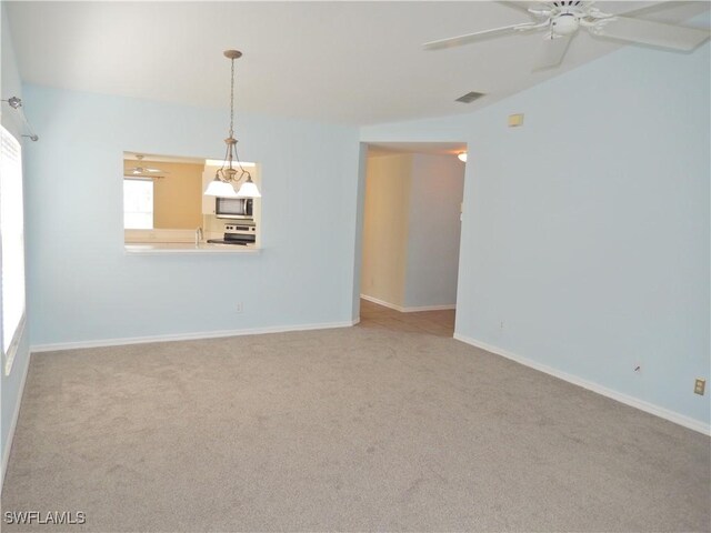 carpeted spare room with ceiling fan and lofted ceiling