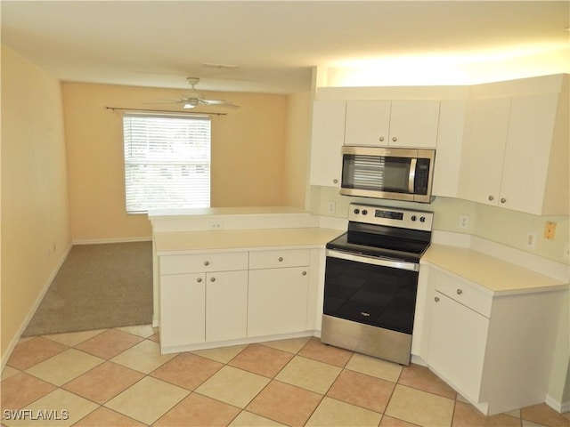 kitchen with white cabinets, light carpet, ceiling fan, kitchen peninsula, and appliances with stainless steel finishes