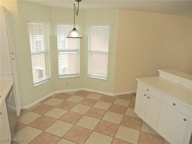 unfurnished dining area with light tile patterned flooring