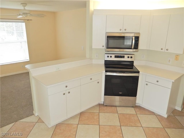 kitchen with stainless steel appliances, white cabinetry, kitchen peninsula, and light tile patterned floors