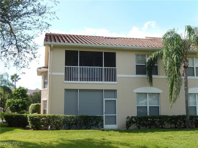 14521 Daffodil Dr Unit 1508, Fort Myers, FL 33919 - back of house with stucco siding, a tiled roof, and a lawn