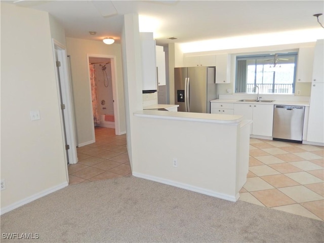 14521 Daffodil Dr Unit 1508, Fort Myers, FL 33919 - kitchen with stainless steel appliances, a sink, white cabinets, light countertops, and light colored carpet
