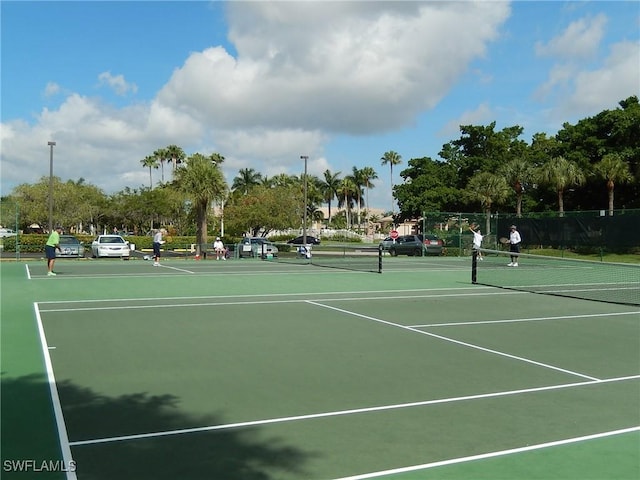 view of tennis court with fence and community basketball court