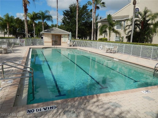 community pool featuring fence and a patio area