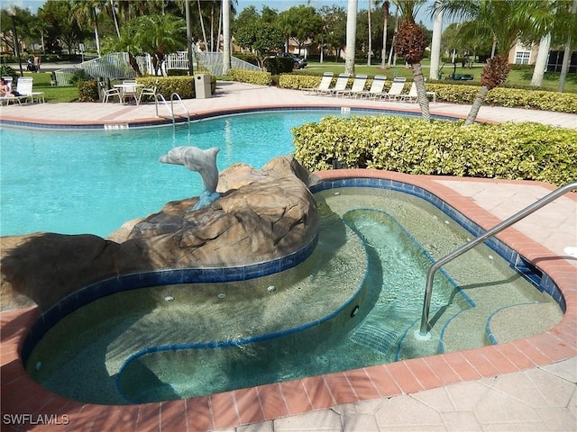 community pool featuring a hot tub