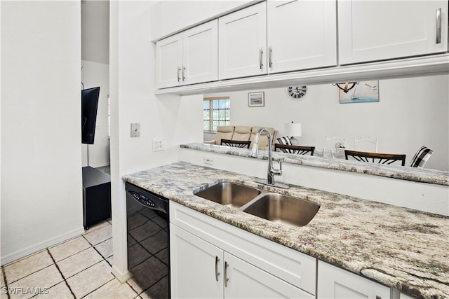 kitchen featuring dishwasher, light tile patterned floors, sink, light stone counters, and white cabinets