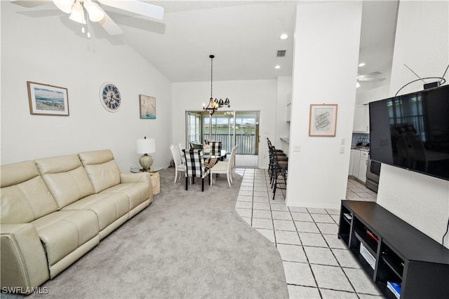 carpeted living room with ceiling fan with notable chandelier and high vaulted ceiling