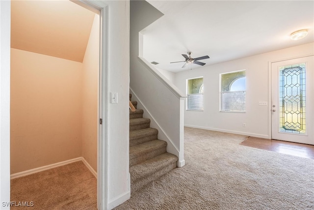 carpeted entryway with ceiling fan and lofted ceiling