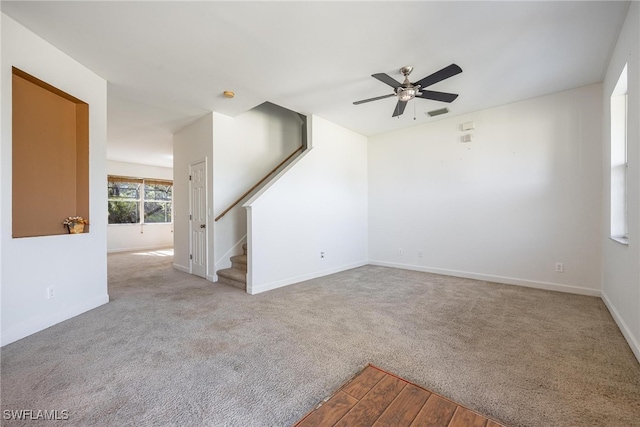 unfurnished living room with light colored carpet and ceiling fan