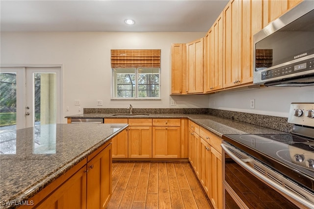 kitchen featuring a wealth of natural light, light hardwood / wood-style floors, appliances with stainless steel finishes, and french doors