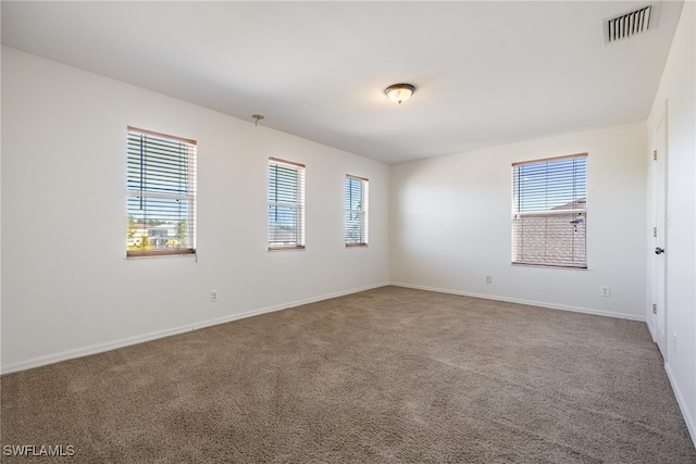 unfurnished room with plenty of natural light and carpet