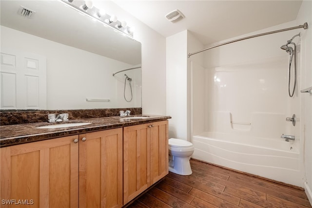 full bathroom with hardwood / wood-style flooring, vanity, shower / bathtub combination, and toilet