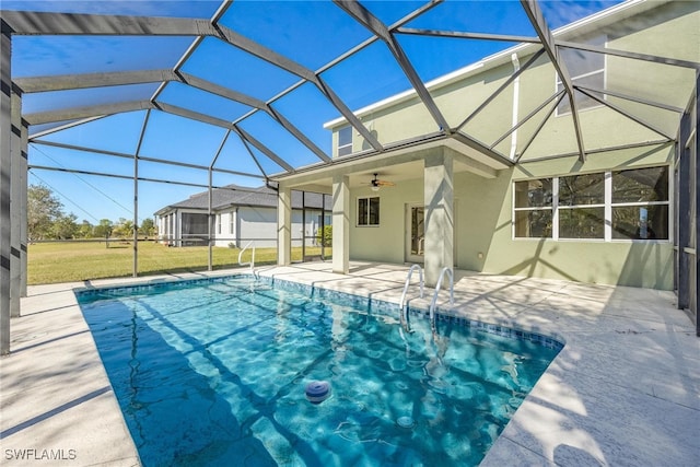 view of swimming pool with a lanai, a patio area, ceiling fan, and a yard