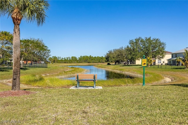 view of home's community with a water view and a lawn