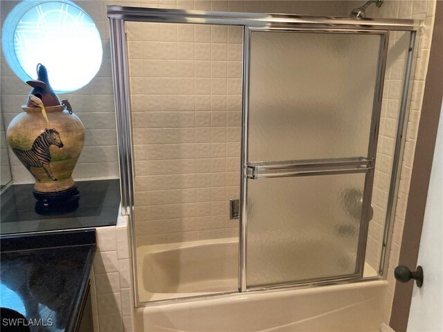 bathroom with vanity and enclosed tub / shower combo