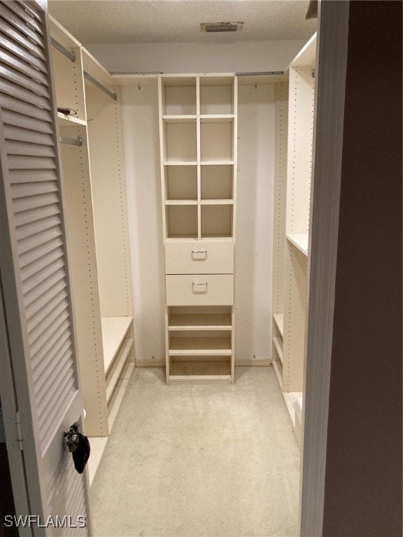 walk in closet featuring light carpet