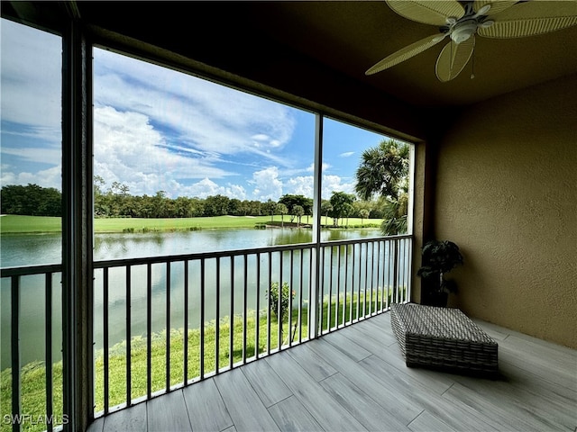 unfurnished sunroom with a water view and ceiling fan