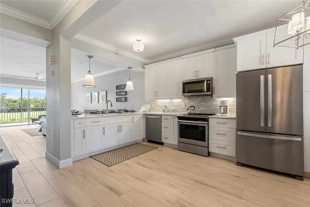 kitchen with pendant lighting, stainless steel appliances, white cabinets, and sink