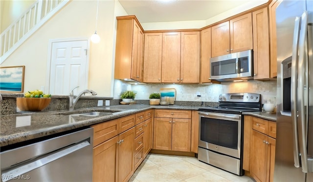 kitchen with sink, appliances with stainless steel finishes, dark stone counters, and decorative backsplash