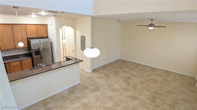 kitchen with ceiling fan, pendant lighting, stainless steel fridge with ice dispenser, and kitchen peninsula