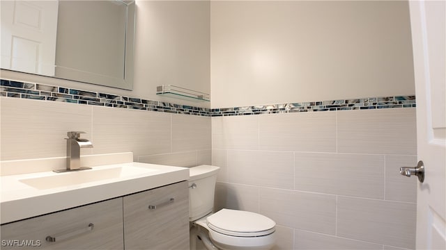 bathroom featuring tile walls, toilet, and vanity