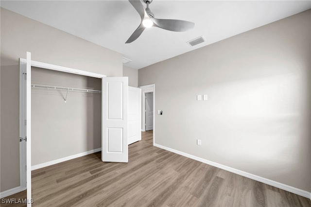 unfurnished bedroom featuring ceiling fan, a closet, and wood-type flooring