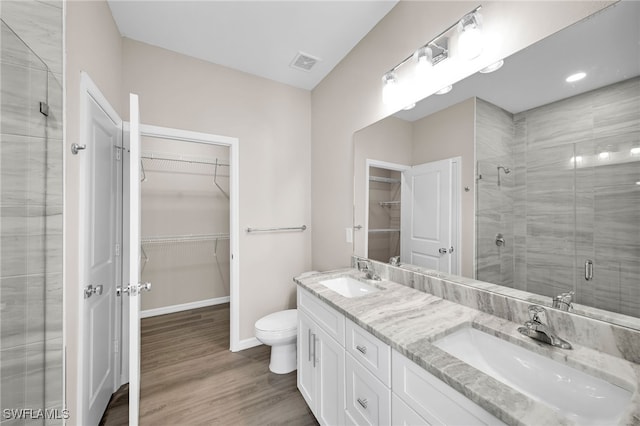 bathroom with walk in shower, toilet, vanity, and hardwood / wood-style floors