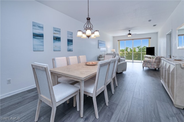 dining room featuring ceiling fan with notable chandelier and dark wood-type flooring