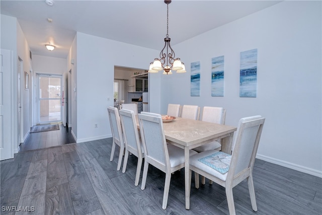 dining space featuring dark hardwood / wood-style flooring and a chandelier