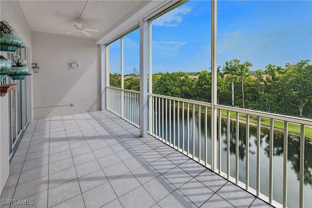 balcony featuring a water view and ceiling fan