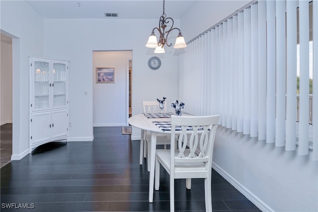 dining area with dark hardwood / wood-style flooring and a chandelier