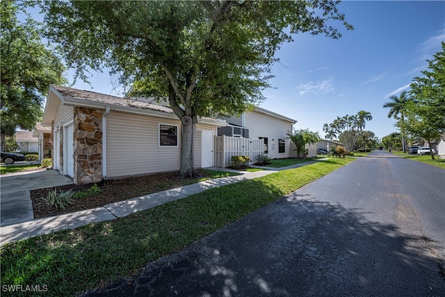 view of front of house featuring a garage, driveway, and stone siding