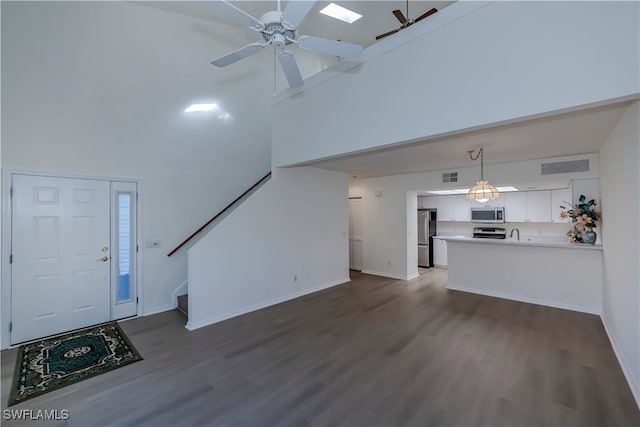 unfurnished living room with stairway, dark wood finished floors, visible vents, and a ceiling fan