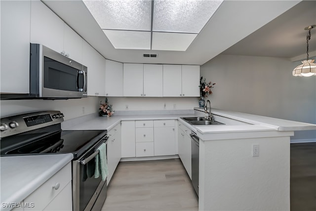 kitchen featuring white cabinetry, stainless steel appliances, a sink, and light countertops