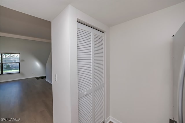 corridor featuring dark wood-style floors and baseboards