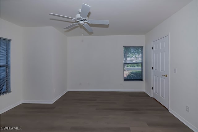 spare room featuring ceiling fan, baseboards, and dark wood finished floors