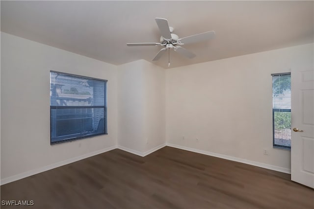 unfurnished room with dark wood-style flooring, ceiling fan, and baseboards