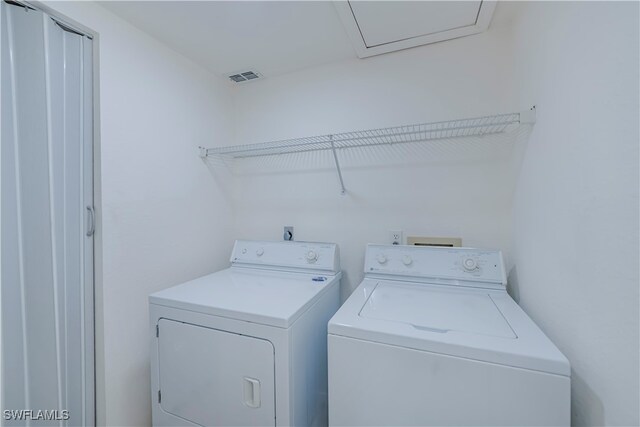 laundry room with washing machine and dryer, laundry area, and visible vents