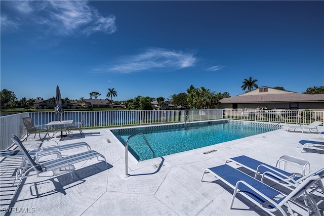 community pool featuring fence and a patio