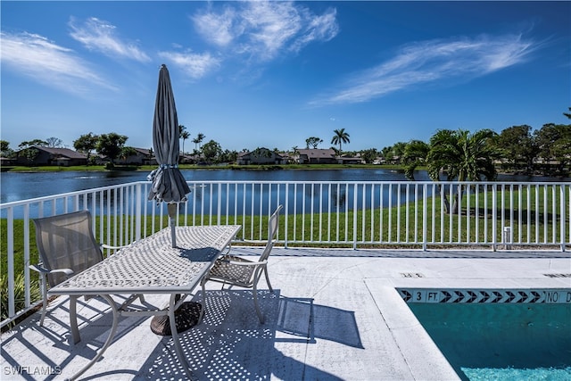 view of patio featuring a water view and fence