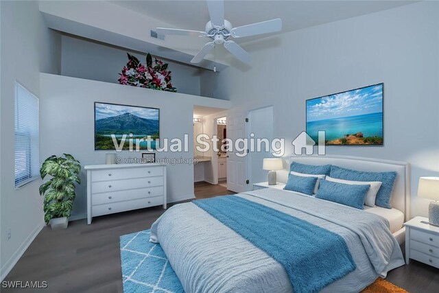 bedroom with connected bathroom, a high ceiling, visible vents, and wood finished floors