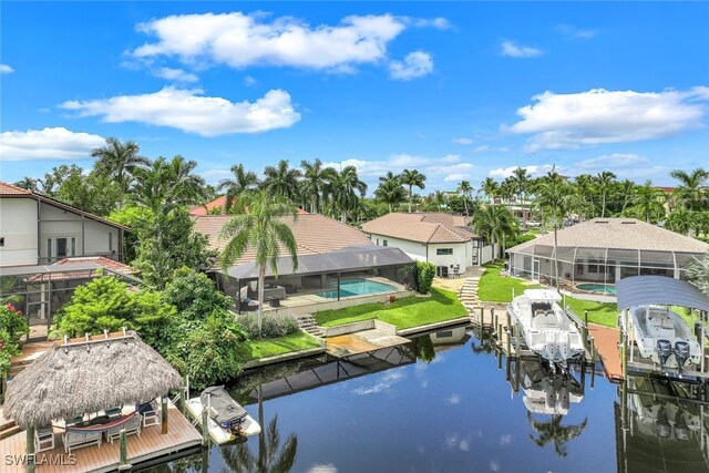 dock area featuring a yard, glass enclosure, and a water view