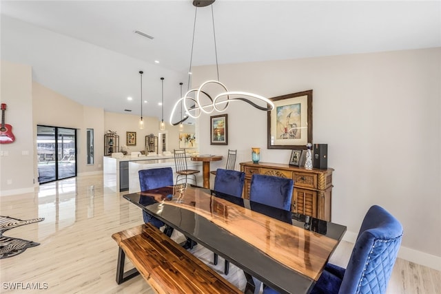 dining space with light hardwood / wood-style floors and vaulted ceiling